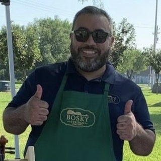 Joel Lee Ozuna smiling outdoors in a Bosky Strings apron