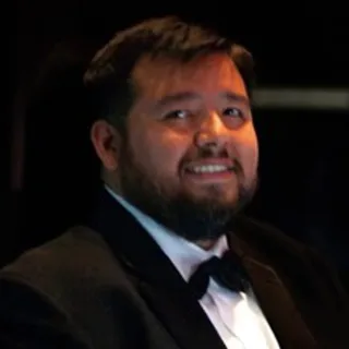 Miguel Javier Gutierrez in a tuxedo performing with his violin on stage